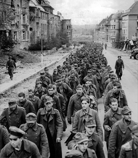 Battle of Aachen: German POWs march through ruined street, Aachen, October 1944